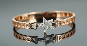Macro detail of rose gold star bracelet with micro-paved crystals and chain design