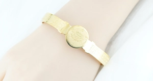 Detailed macro view of gold plated lotus flower embossment and Buddhist scriptures on the cuff