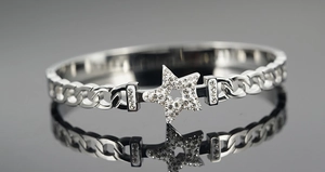 Detailed view of stainless steel star bracelet with sparkling crystals and cuban chain texture