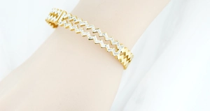 Close-up of zigzag gold bangle featuring a layer of sparkling white cubic zirconia stones