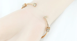 Dettaglio del bracciale aperto in oro rosa e acciaio al titanio con anelli di cristalli