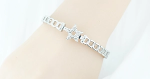Detail view of silver Cuban chain bracelet with a sparkling crystal-encrusted star charm