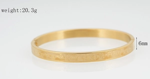 Detailed macro view of 6mm gold stainless steel bangle with engraved mantra script