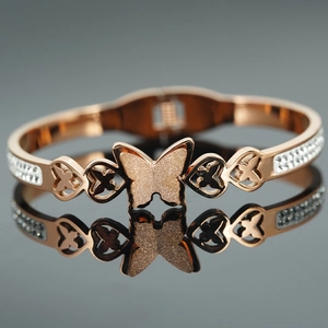 Bracciale a farfalla oro rosa con ali satinate e strass scintillanti su fascia lucida