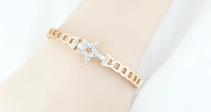 Close-up of rose gold star bracelet with pavé diamonds worn on a female wrist