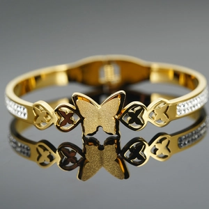 Elegante bracciale rigido dorato a farfalla con zirconi lucidi e design a cuore aperto