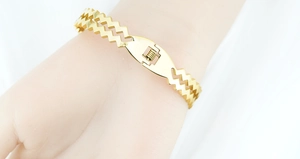 Detail view of gold double-layer zigzag bangle with diamond accents on a female wrist