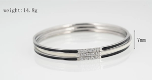 Detail view of a 7mm width triple-layered titanium steel bangle with zircon inlay