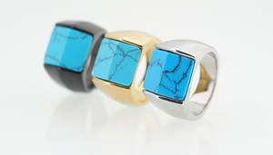 Détails de trois bagues chevalières turquoise en finitions noir, doré et argenté