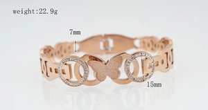 Detail view of rose gold butterfly bangle with frosted finish and diamond accents