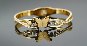Detail van gouden vlinderarmband met matte afwerking en sprankelende kristallen