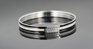 Macro view of triple-layer titanium steel bracelet with enamel inlay and pavé crystals