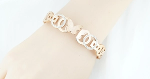 Detailed close-up of a rose gold butterfly bangle with pavé crystals on the wrist