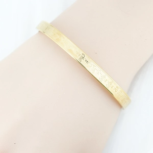 Golden titanium steel bangle with engraved Buddhist Sanskrit mantra for women