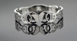 Detailed close-up of a silver butterfly charm bracelet with sparkling inlaid rhinestones