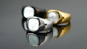 Macro detail of titanium steel signet rings with square mother of pearl inlay