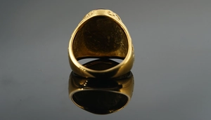 Close-up of vintage gold titanium steel ring featuring intricate engraved scroll patterns