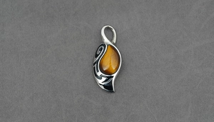 Detailed view of a vintage tiger eye stone pendant with intricate silver engravings