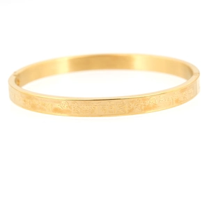 Polished gold plated titanium steel mantra bangle with detailed Sanskrit engravings