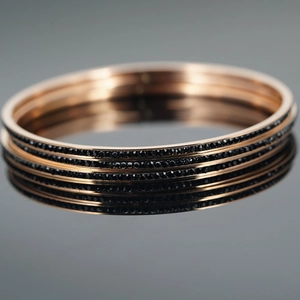 Lot de trois joncs en or rose avec zircons noirs pavés et reflets élégants sur fond gris