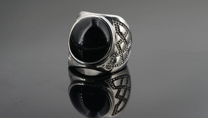 Détail macro d'une bague vintage en argent pour homme avec une grande pierre d'obsidienne