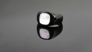 Detail view of a black titanium steel ring featuring a square white mother of pearl inlay