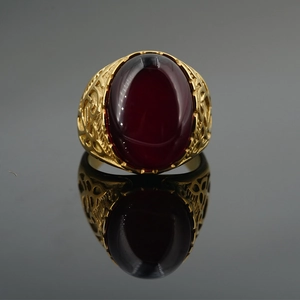Vintage gold plated ring with large red gemstone and intricate hollow patterns