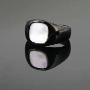 Black titanium signet ring with square white mother of pearl inlay on gray background