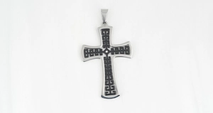 Dettaglio del ciondolo a croce in acciaio inossidabile con motivi geometrici e diamante