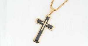 Close-up of dual-layer cross pendant in gold and black finish with round box chain link