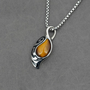 Tribal tiger eye stone pendant with black enamel patterns on a box chain for women