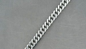 Detailed view of polished silver cuban link chain necklace with smooth metallic finish