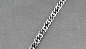 Close-up detail of silver polished Cuban link chain with high mirror reflection finish