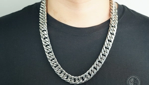 Close-up of thick silver stainless steel Cuban link chain necklace on a male model