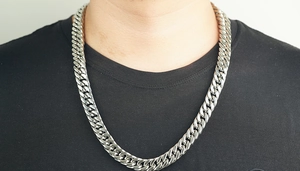 Close-up of heavy silver stainless steel Cuban link chain necklace on male model