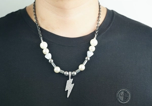 Détail du pendentif éclair en cristaux avec chaîne de perles pour hommes