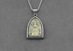 Dettaglio del ciondolo Buddha in acciaio argento con divinità dorata e incisioni vintage