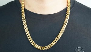 Détail du collier chaîne cubaine dorée de 12 mm pour homme sur un t-shirt noir