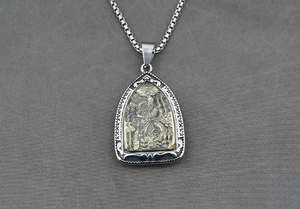 Détail d'un pendentif Guan Yu vintage sur une chaîne à mailles carrées en argent