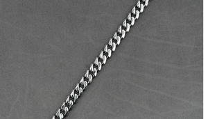 Primer plano detallado de una cadena de eslabones cubanos de acero inoxidable pulido plata