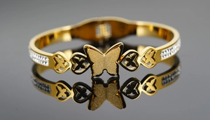 Détail macro du bracelet papillon doré avec sertissage de cristaux et finition mate