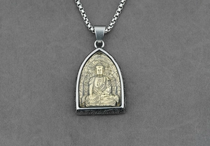 Dettaglio del ciondolo Buddha in acciaio al titanio con rilievo dorato e bordo inciso