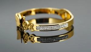 Vue détaillée du bracelet papillon doré avec cœurs ajourés et cristaux pavés brillants