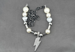 Détail du collier punk avec perles blanches, chaîne épaisse et pendentif éclair en zircon