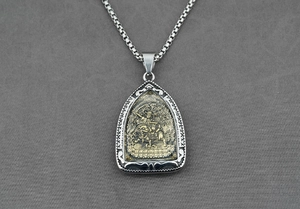 Détail du pendentif en argent rétro avec motif en relief doré d'une divinité protectrice