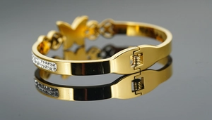 Détail du bracelet papillon doré avec des strass étincelants et un fermoir à ressort
