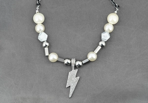 Détail macro du pendentif éclair punk avec cristaux blancs et perles de marbre