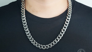 Primer plano de un collar de cadena cubana de acero inoxidable sobre una camiseta negra