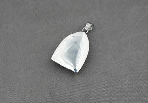 Détail macro du pendentif poli en acier inoxydable en forme de cloche effet miroir