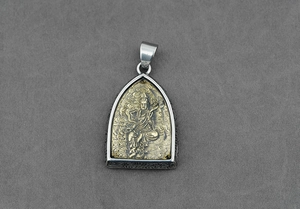 Dettaglio del ciondolo amuleto buddista thailandese in argento vintage e finitura dorata